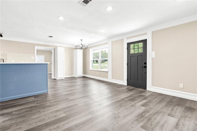 foyer with dark hardwood / wood-style flooring, a chandelier, and ornamental molding