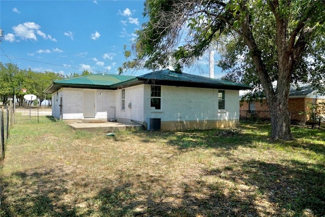 rear view of property with a patio and a lawn