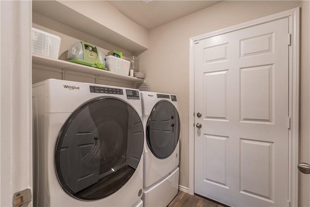 laundry area with dark hardwood / wood-style floors and washer and clothes dryer