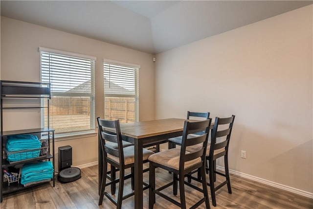 dining space with lofted ceiling and hardwood / wood-style floors