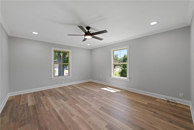 spare room featuring hardwood / wood-style floors, crown molding, and a wealth of natural light