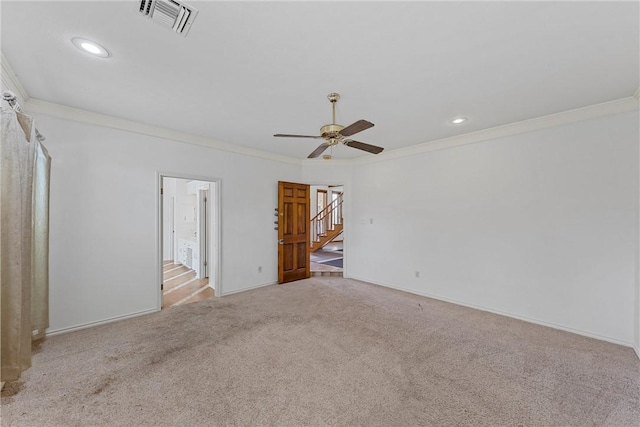 empty room featuring ceiling fan, crown molding, and light carpet