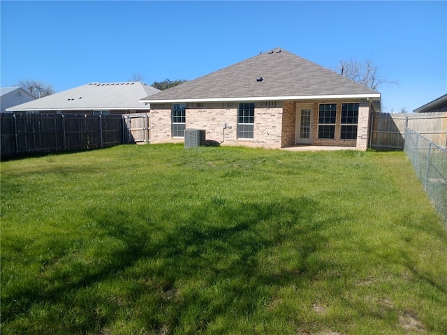 rear view of house featuring a yard, central AC, and a patio area