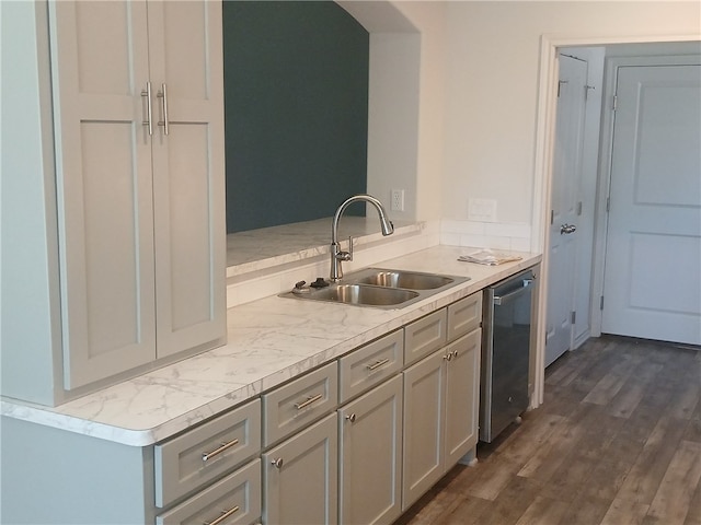 kitchen with sink, gray cabinetry, light stone countertops, dark hardwood / wood-style flooring, and stainless steel dishwasher