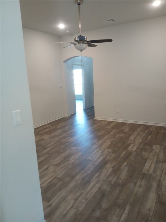 empty room with dark hardwood / wood-style flooring and ceiling fan