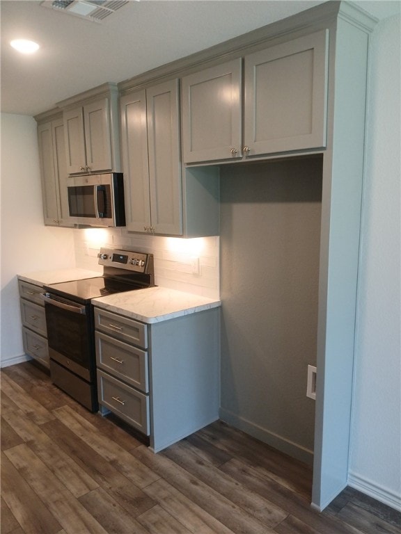 kitchen featuring appliances with stainless steel finishes, dark wood-type flooring, and gray cabinetry