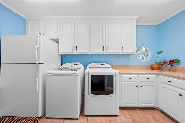 laundry room with cabinets, washing machine and dryer, crown molding, and light tile patterned flooring