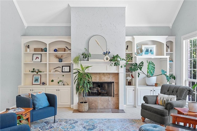 living area featuring built in shelves, ornamental molding, and a fireplace