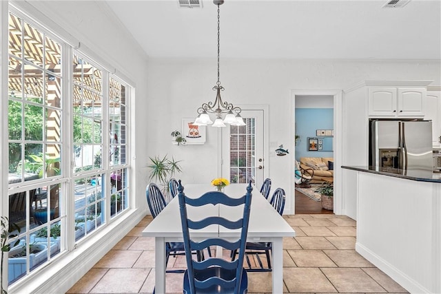 tiled dining room with crown molding and a notable chandelier