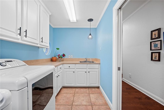 laundry room featuring sink, cabinets, light hardwood / wood-style floors, washer / dryer, and ornamental molding