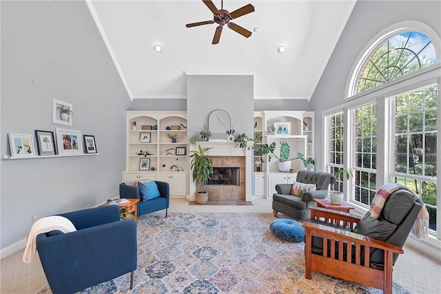 carpeted living room featuring ceiling fan, high vaulted ceiling, plenty of natural light, and a tiled fireplace