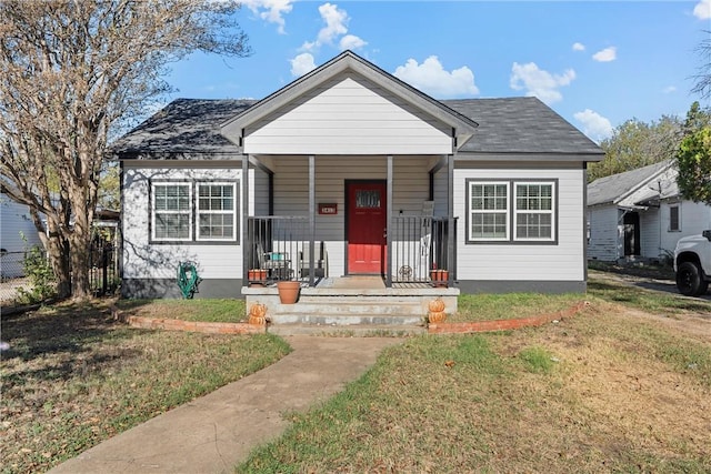 bungalow-style home featuring covered porch and a front yard