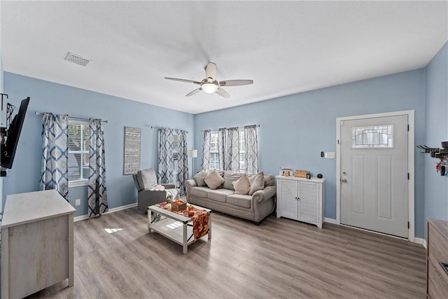 living room featuring hardwood / wood-style floors, ceiling fan, and a wealth of natural light