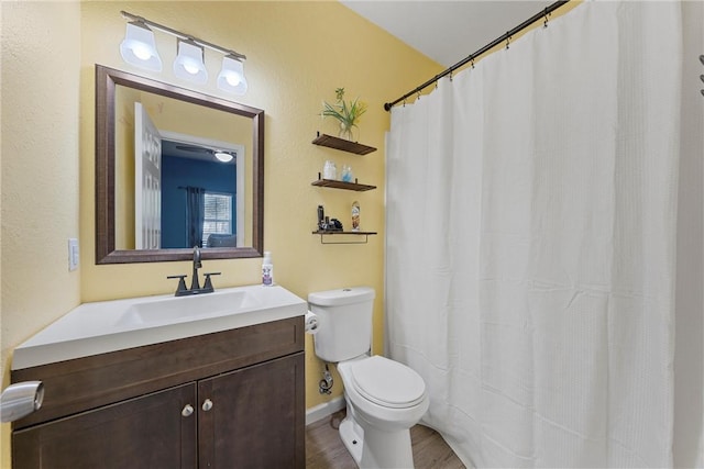 bathroom with hardwood / wood-style floors, vanity, and toilet