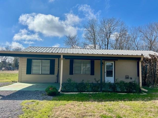 single story home with a front lawn and a carport