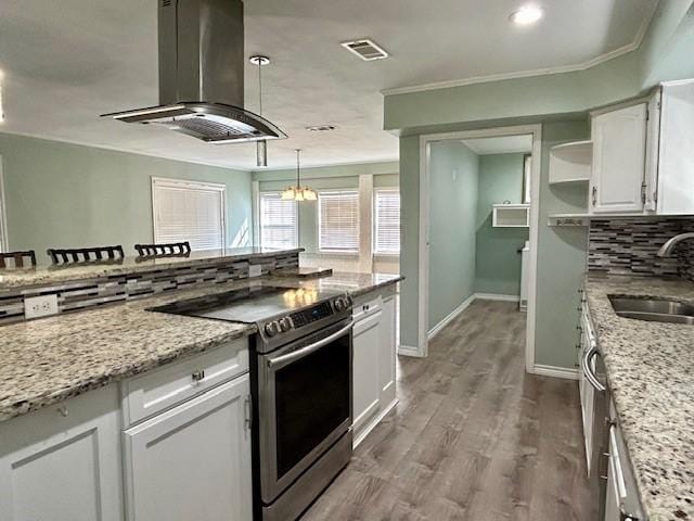 kitchen featuring sink, stainless steel electric range oven, island exhaust hood, light stone countertops, and white cabinets