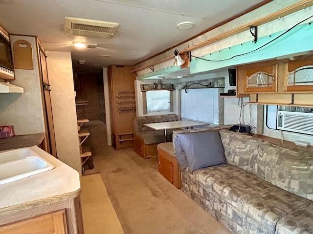 kitchen with cooling unit, sink, and light carpet