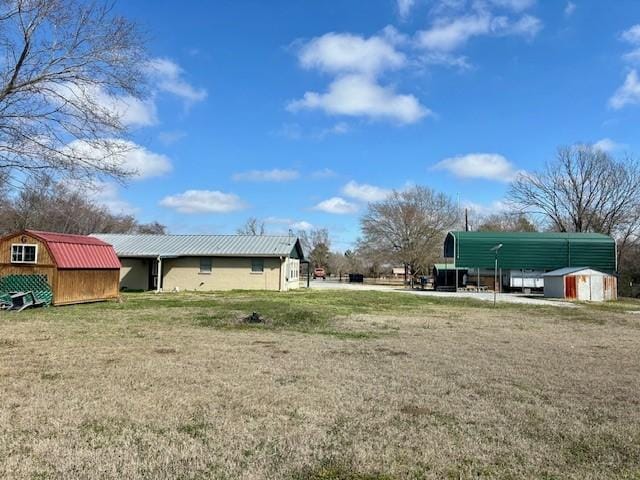 view of yard featuring a carport and a storage shed