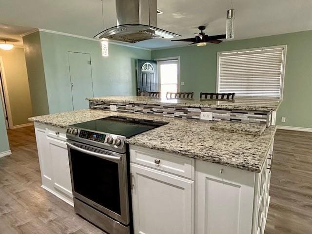 kitchen featuring electric stove, light hardwood / wood-style flooring, white cabinets, and island exhaust hood