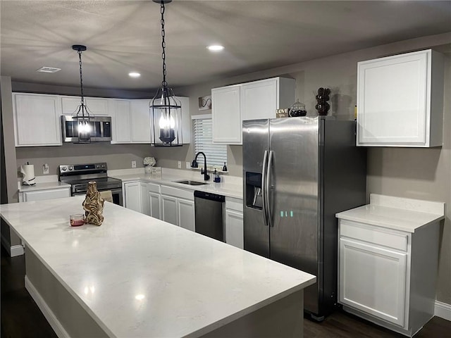 kitchen featuring pendant lighting, a center island, sink, appliances with stainless steel finishes, and white cabinetry