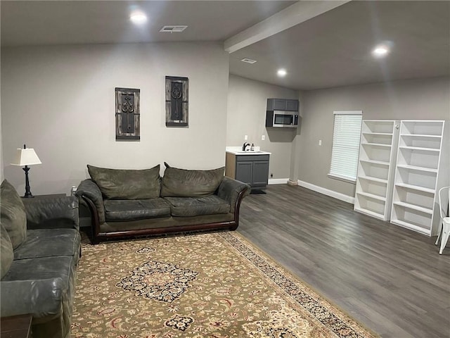 living room featuring dark hardwood / wood-style floors, vaulted ceiling, and sink