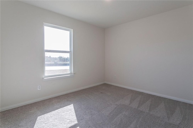 empty room featuring carpet floors and baseboards