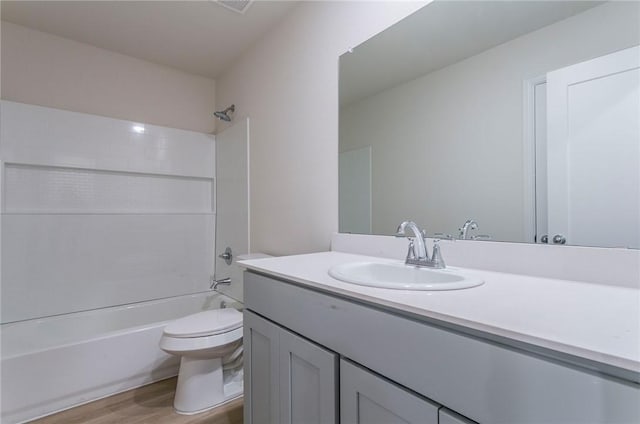 bathroom with toilet, shower / bathtub combination, wood finished floors, and vanity