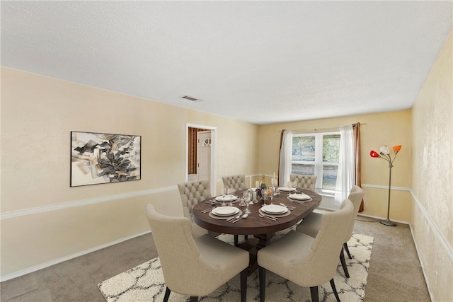 carpeted dining area with a textured ceiling