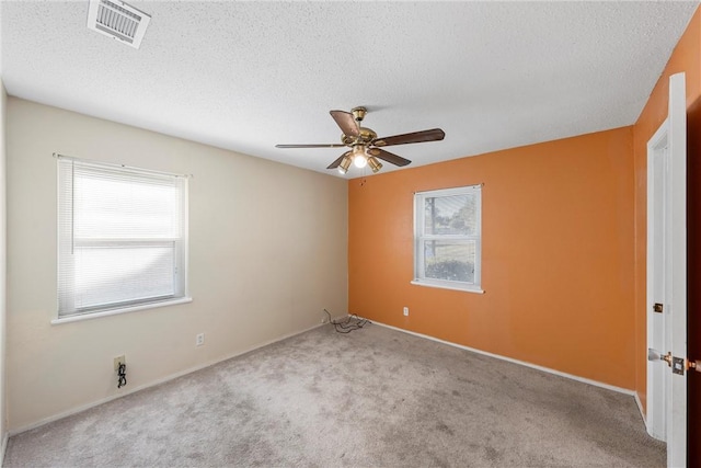 carpeted empty room featuring a textured ceiling and ceiling fan