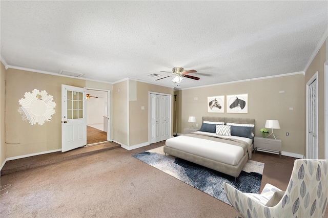 carpeted bedroom featuring a textured ceiling, two closets, ceiling fan, and crown molding