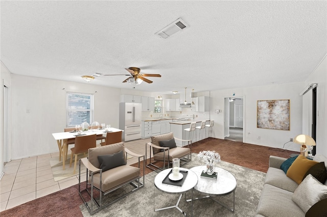 tiled living room with ceiling fan and a textured ceiling