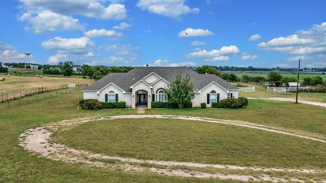 single story home with a rural view and a front yard