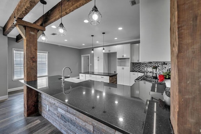 kitchen featuring beam ceiling, white cabinetry, sink, dark wood-type flooring, and decorative light fixtures