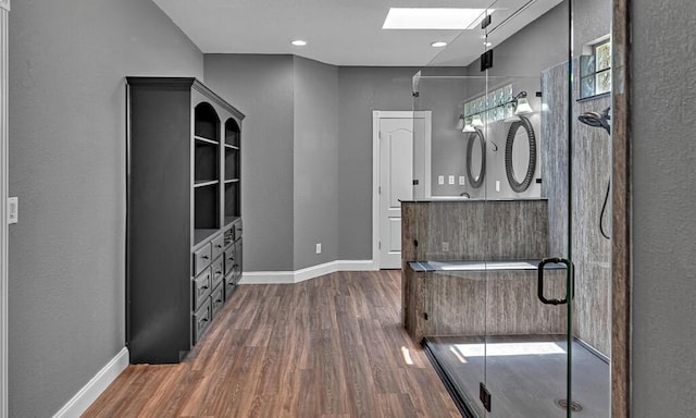 interior space featuring a skylight, dark wood finished floors, and baseboards