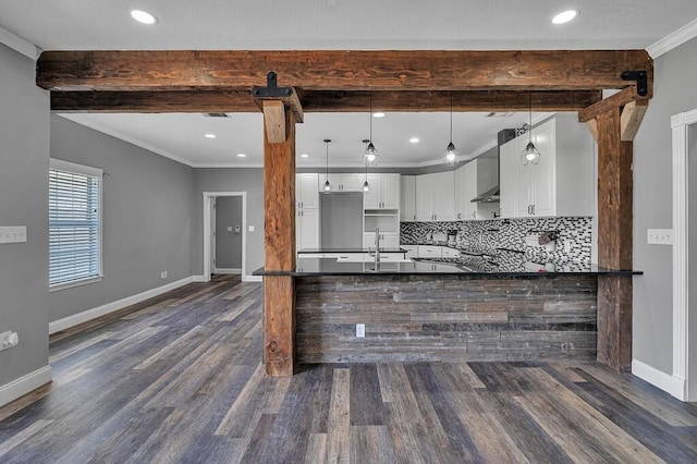 kitchen featuring baseboards, dark countertops, ornamental molding, beam ceiling, and backsplash