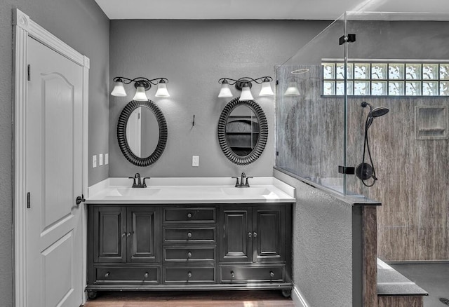 full bath with double vanity, a sink, and a walk in shower