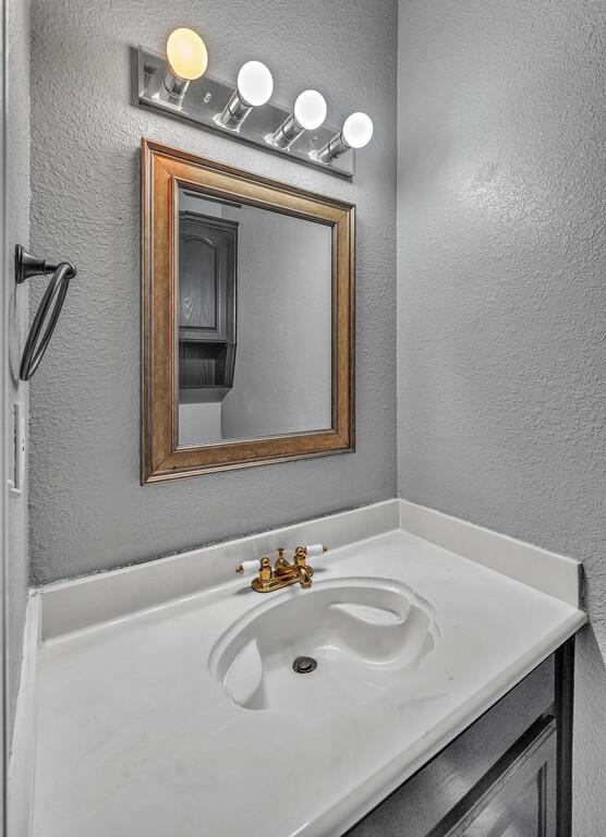 bathroom featuring a textured wall and vanity