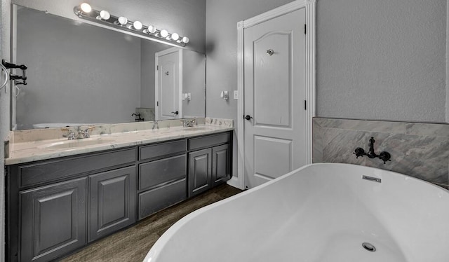 bathroom featuring hardwood / wood-style floors, vanity, and a bath