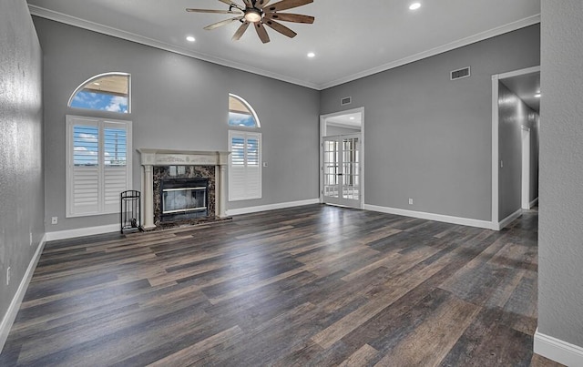 unfurnished living room featuring ceiling fan, dark hardwood / wood-style flooring, a premium fireplace, and ornamental molding