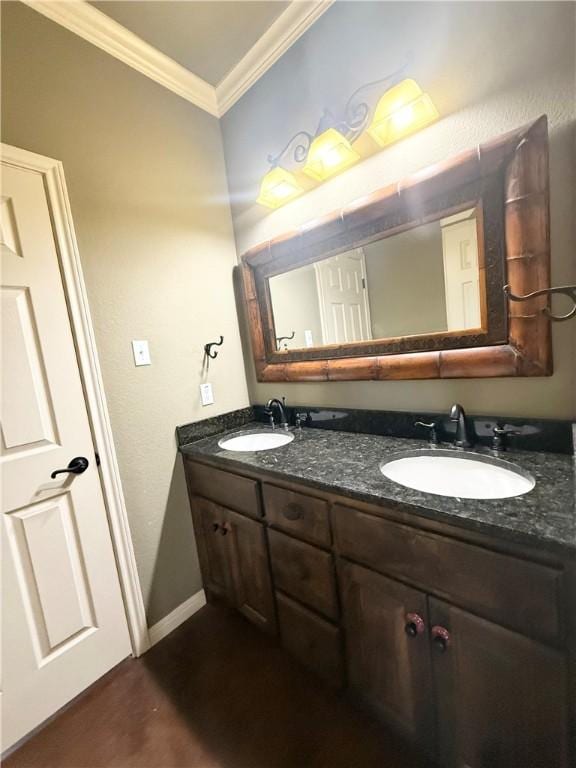 bathroom featuring double vanity, ornamental molding, baseboards, and a sink