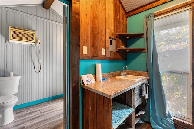 bathroom featuring lofted ceiling with beams, wood-type flooring, sink, and a wealth of natural light