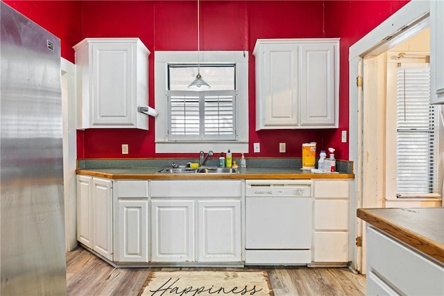 kitchen with white cabinetry, sink, white dishwasher, pendant lighting, and light hardwood / wood-style floors