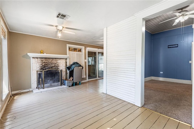 interior space with a fireplace, crown molding, hardwood / wood-style floors, and ceiling fan