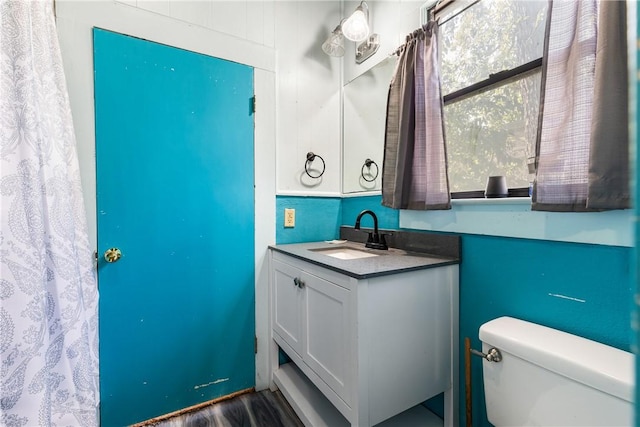 bathroom with hardwood / wood-style floors, vanity, and toilet