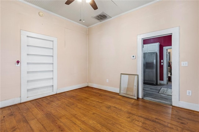 spare room with hardwood / wood-style floors, crown molding, ceiling fan, and built in shelves