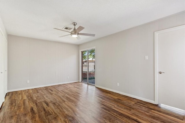 spare room featuring visible vents, baseboards, wood finished floors, and a ceiling fan