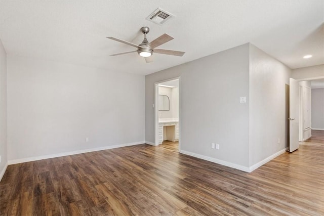 interior space featuring ceiling fan, visible vents, baseboards, and wood finished floors