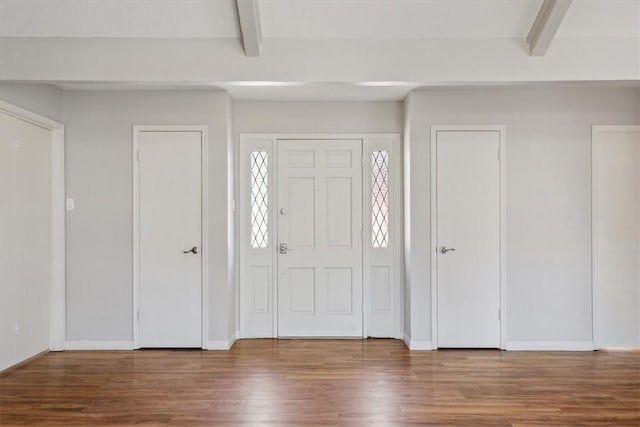 entrance foyer with baseboards, beam ceiling, and wood finished floors