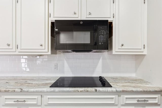 details featuring light stone counters, decorative backsplash, white cabinets, and black appliances