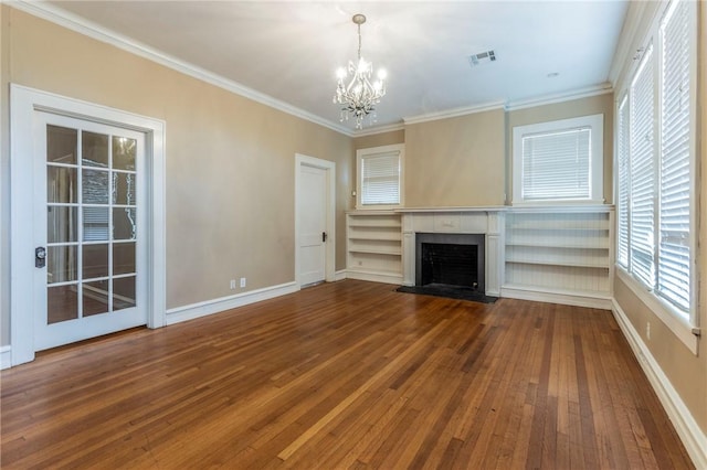 unfurnished living room with hardwood / wood-style flooring, crown molding, and a chandelier